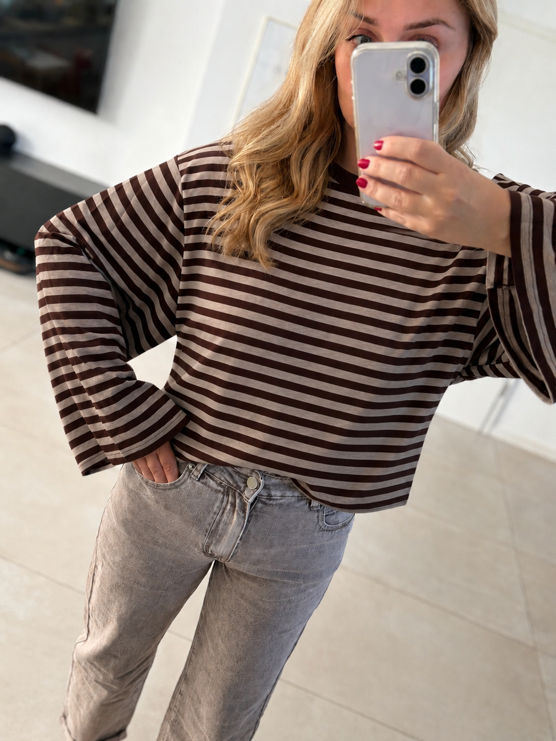 Model trägt ein gestreiftes Oversize-Langarmshirt in Dunkelbraun