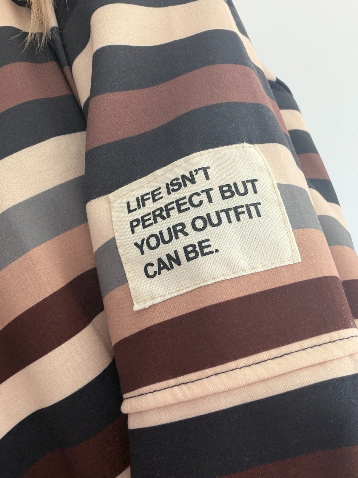 Butterweicher Streifen-Pullover – Detailansicht mit Statement-Patch am Ärmel