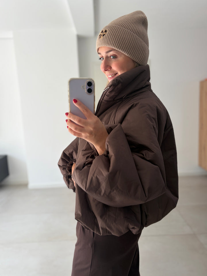 Dunkelbraune Puffy Oversize-Ballonjacke am Model – Dreiviertelansicht mit hohem Kragen und voluminösen Ärmeln