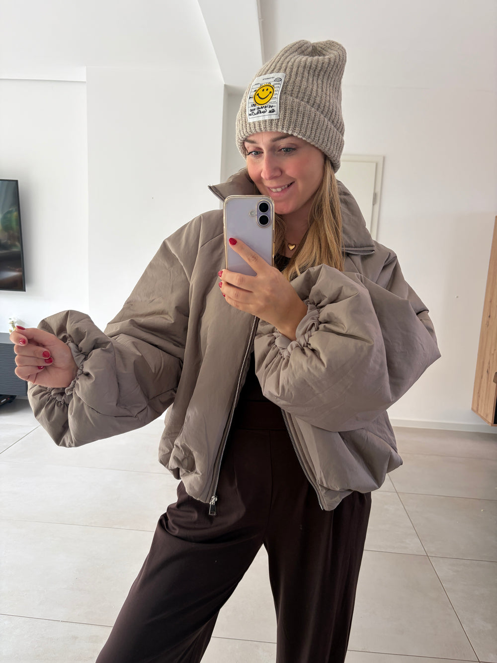 Taupefarbene Puffy Oversize-Ballonjacke am Model – offene Front und ausgestreckter Statement-Ärmel