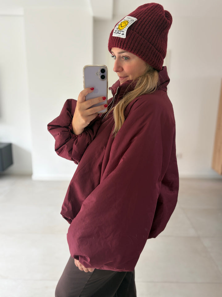Bordeauxrote Puffy Oversize-Ballonjacke am Model – seitliche Ansicht von Kragen und weitem Ärmel