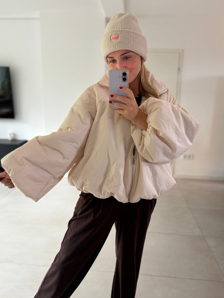 Cremefarbene Puffy Oversize-Ballonjacke am Model – Oberkörperansicht mit Stehkragen und weitem Ärmel