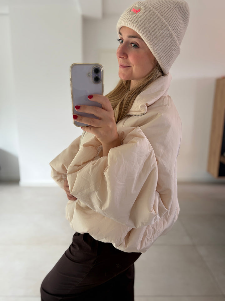 Cremefarbene Puffy Oversize-Ballonjacke am Model – Seitenansicht von Stehkragen und Ballonärmel