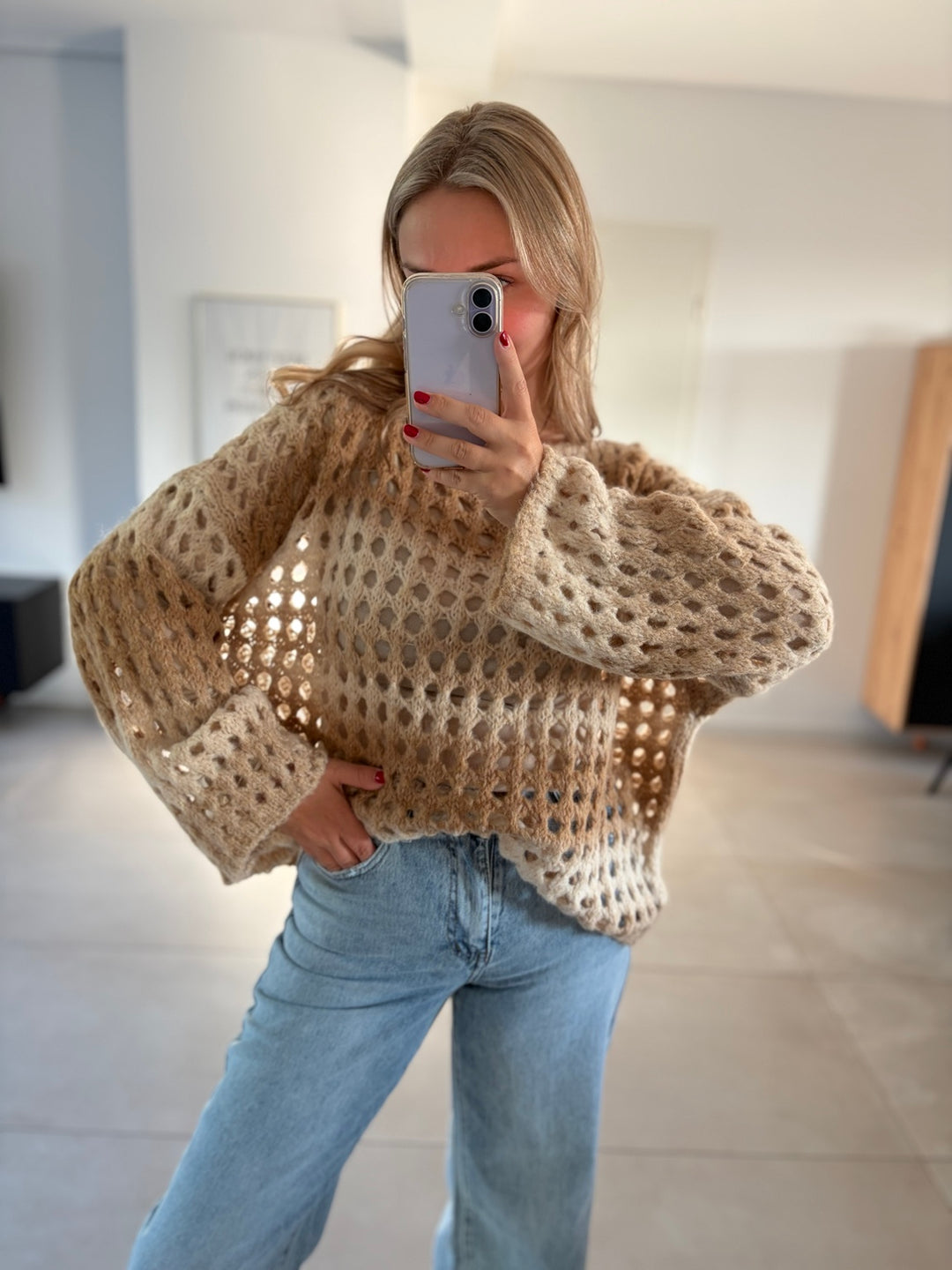 Taupe-beiger Oversize-Ajourstrickpullover mit weiten Ärmeln, getragen zu heller Jeans