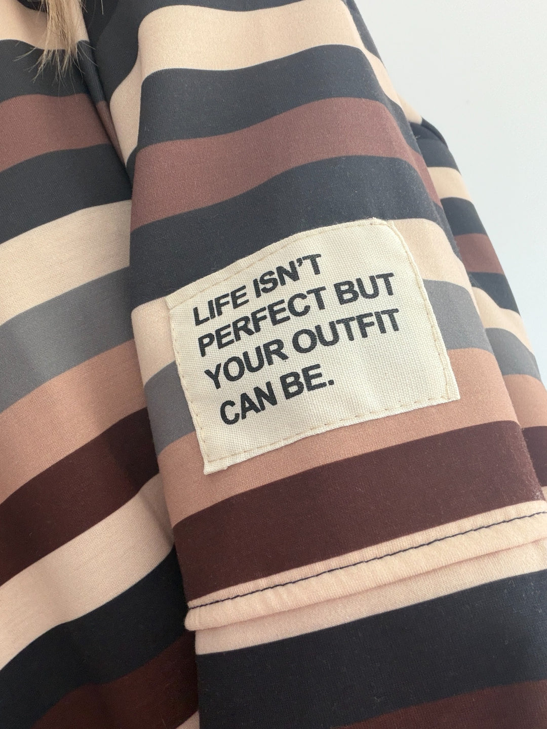 Butterweicher Streifen-Pullover – Detailansicht mit Statement-Patch am Ärmel