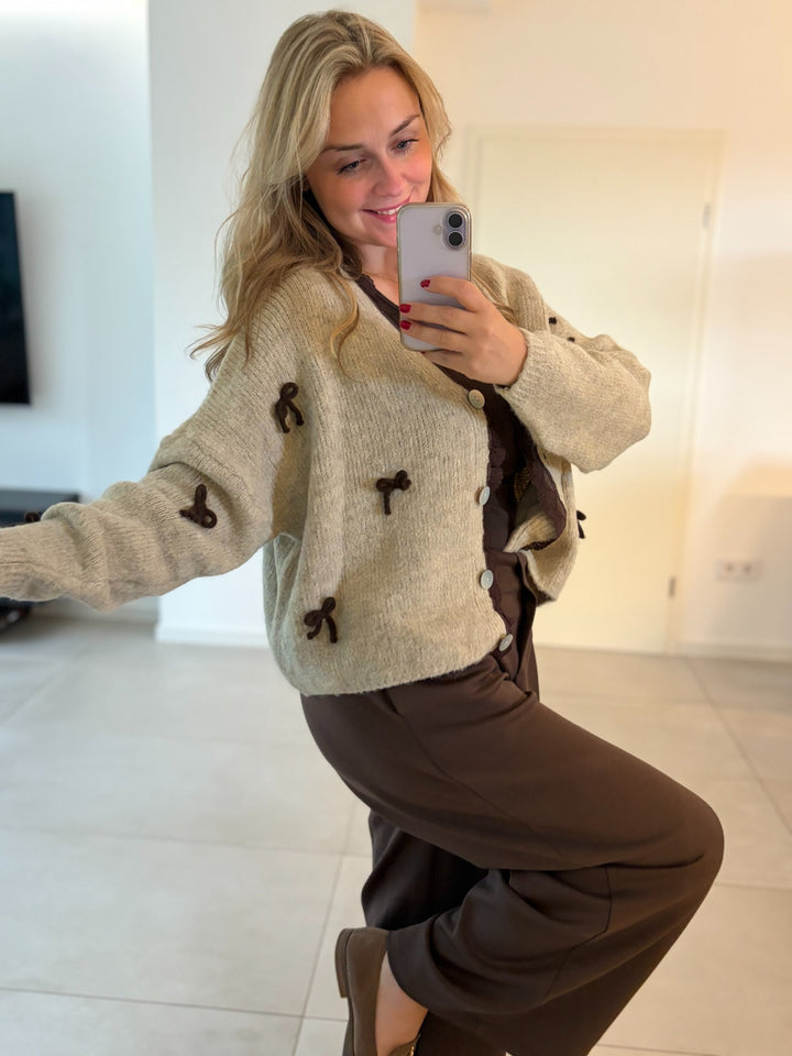 Beige Strickjacke mit Schleifen-Applikationen – seitlich getragen