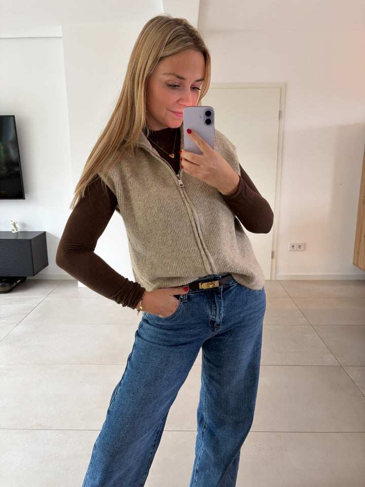 Beige Strickweste mit Reißverschluss kombiniert mit braunem Longsleeve und blauer Jeans