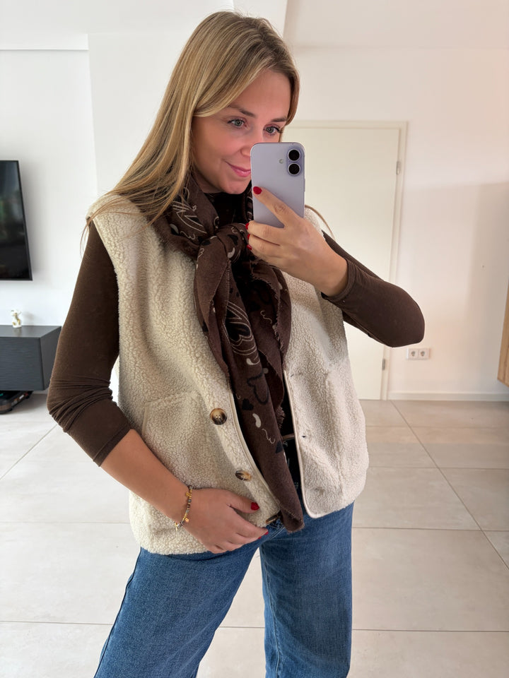 Teddy-Weste in Creme mit Knöpfen, kombiniert mit braunem Longsleeve, Jeans und Schal